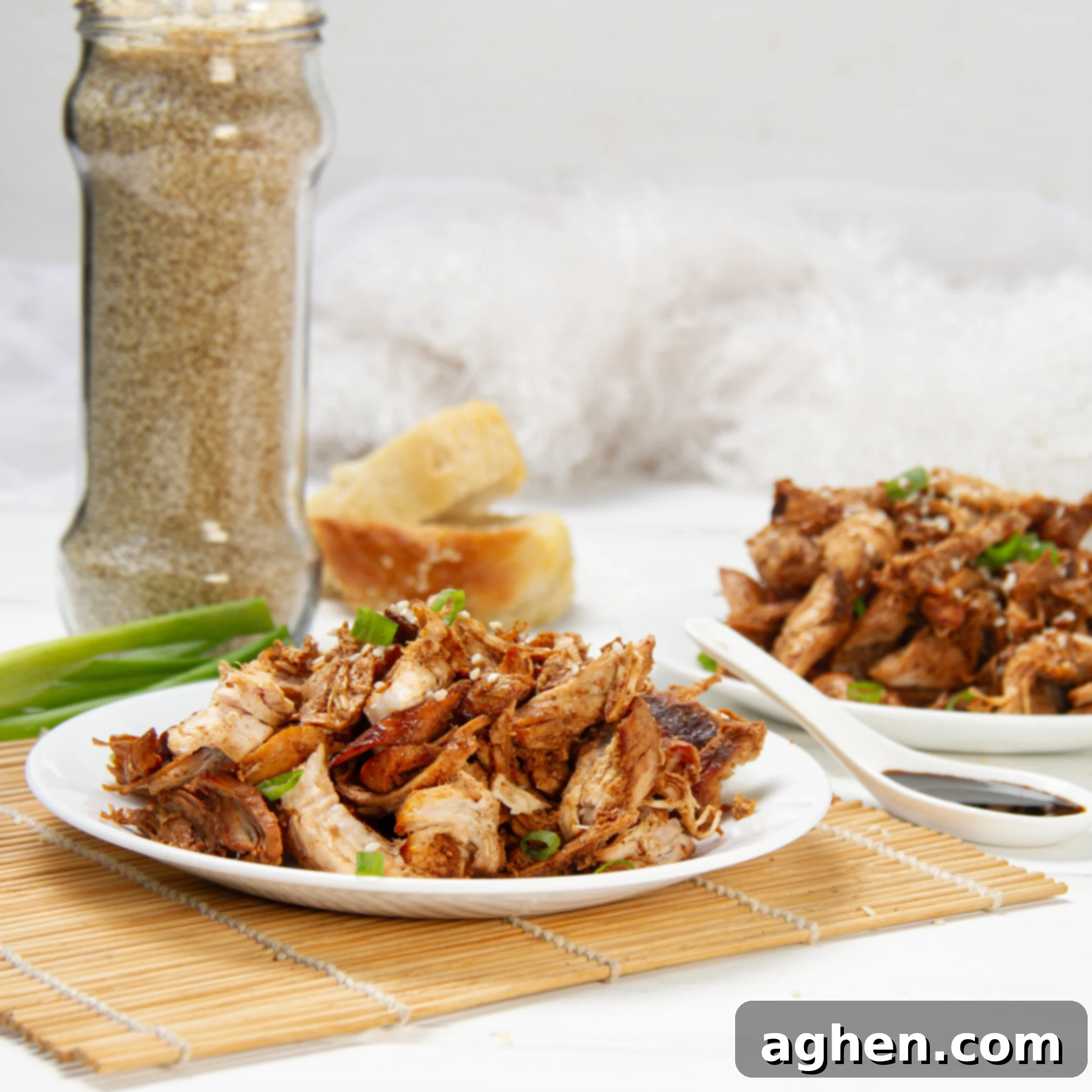 Crispy Chinese shredded chicken on a plate, garnished with fresh herbs.