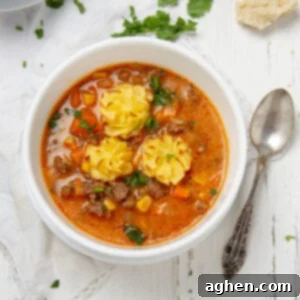 Hearty and delicious Shepherd's Pie Soup in a bowl with a spoon on the side, garnished with golden potato puffs.