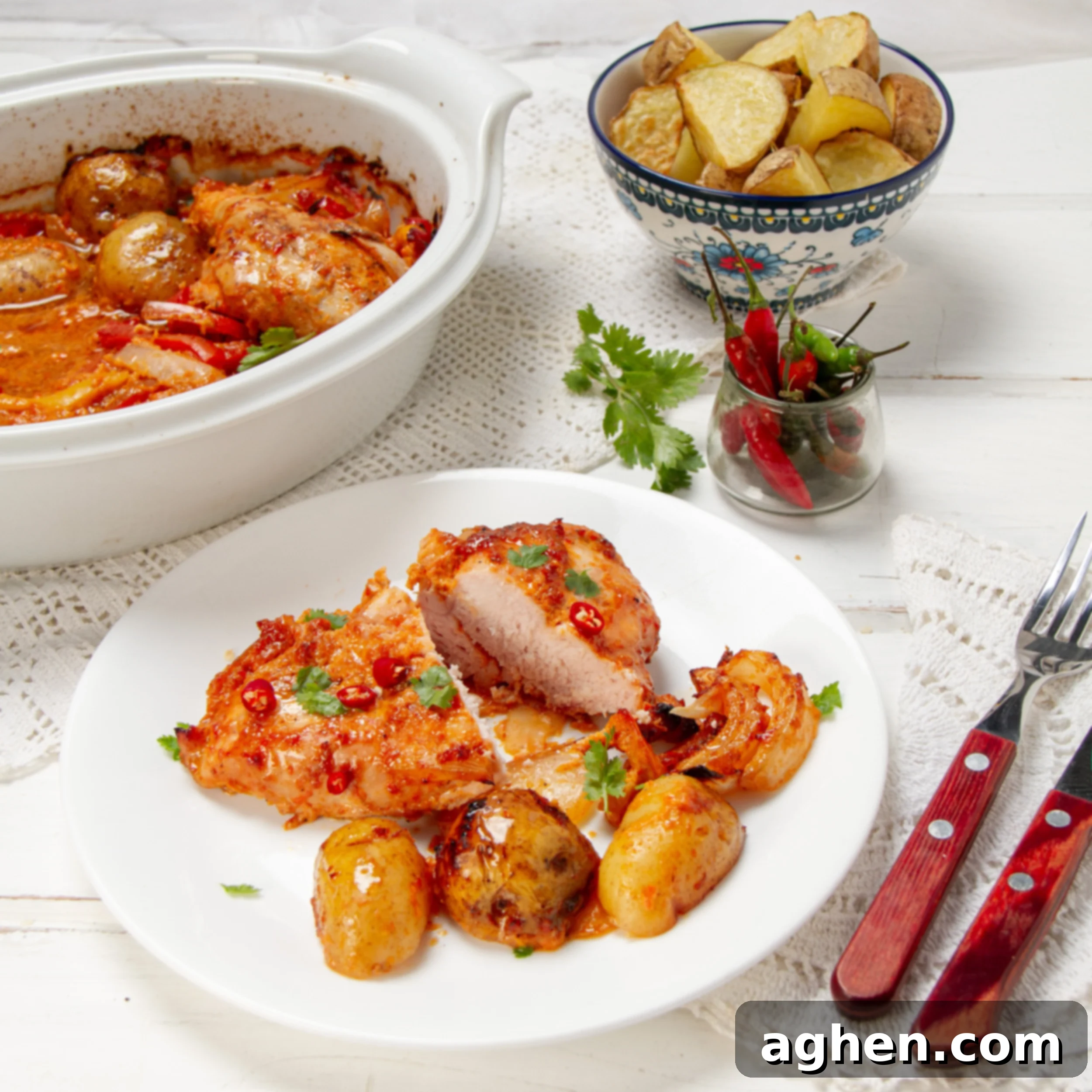 Spicy one pan piri-piri chicken on a plate with potatoes and fresh herbs, ready to be served.