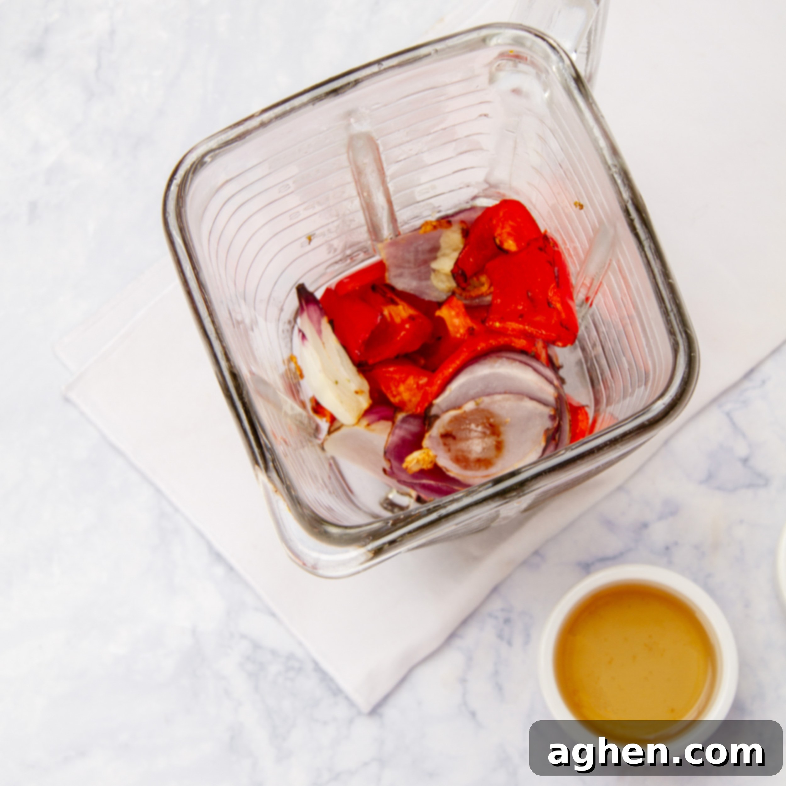 Blender with roasted vegetables and spices, preparing to make the smooth Piri-Piri sauce.