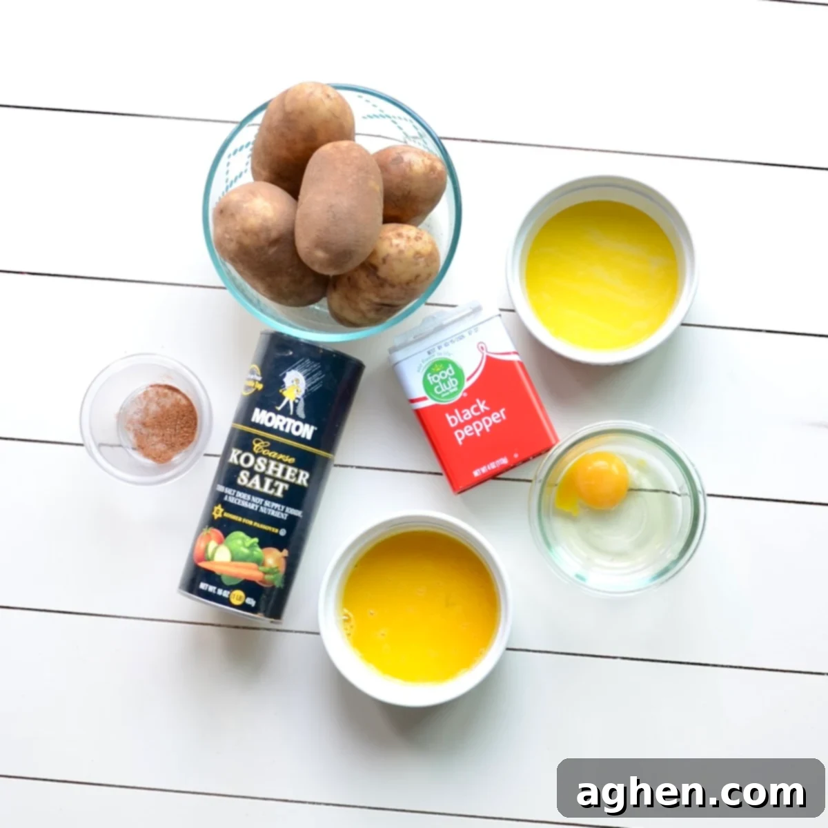 Guilt-Free Weight Watchers Duchess Potatoes 3 A flat lay photograph showcasing the simple, fresh ingredients required for preparing healthy Duchess Potatoes: Russet potatoes, egg yolks, nutmeg, light butter, salt, and pepper.