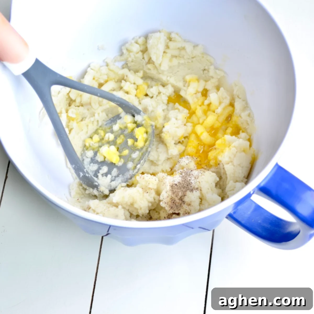 Guilt-Free Weight Watchers Duchess Potatoes 4 Mashed potatoes being mixed with egg yolks and seasonings in a bowl, preparing the mixture for piping Duchess potatoes.