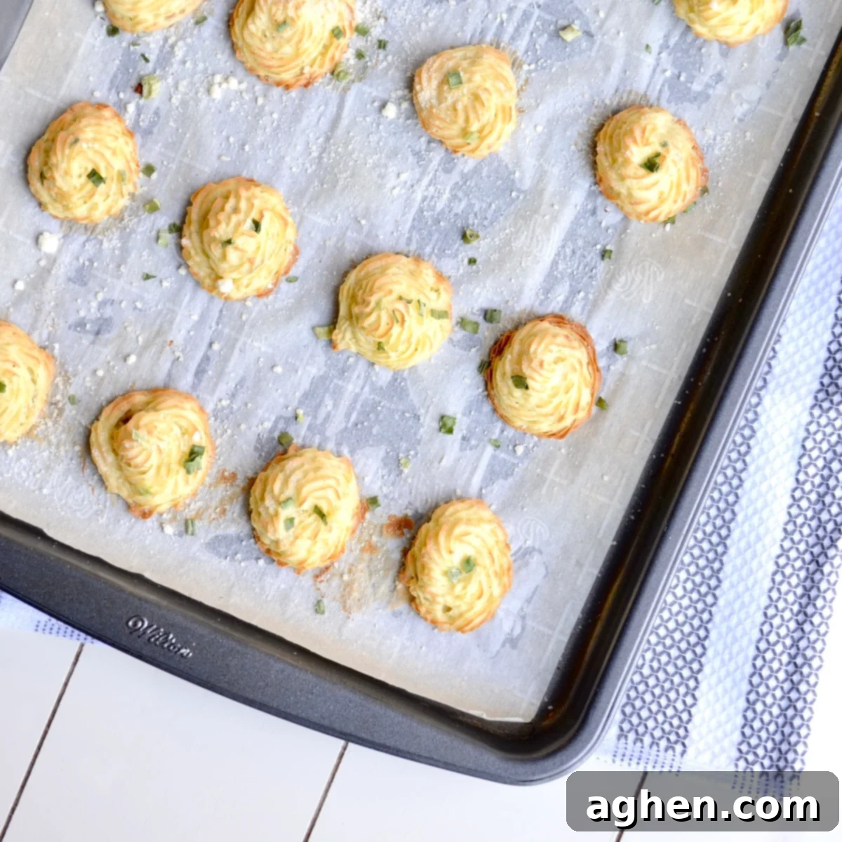 Guilt-Free Weight Watchers Duchess Potatoes 5 Beautifully piped Duchess potatoes baking on a parchment-lined sheet pan, achieving a perfect golden-brown color and crispy texture.