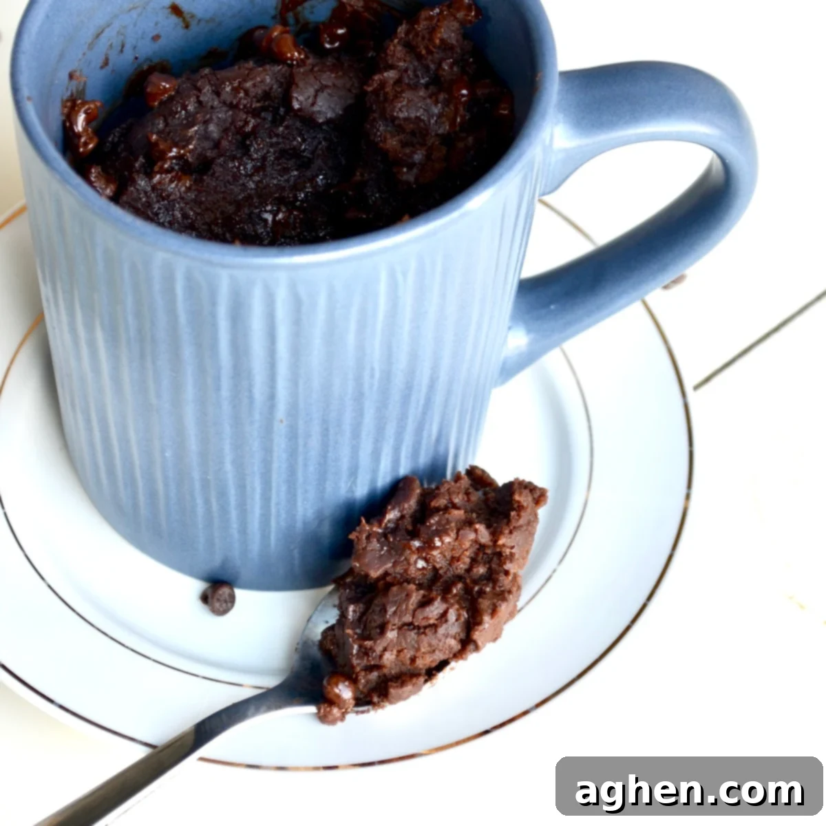 Guilt-Free Brownie Mug Bliss 5 A spoonful of rich, warm brownie next to a mug, showing its fudgy texture