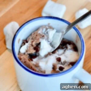 Upclose image of hot cocoa mug cake, generously topped with marshmallows, ready to be enjoyed.