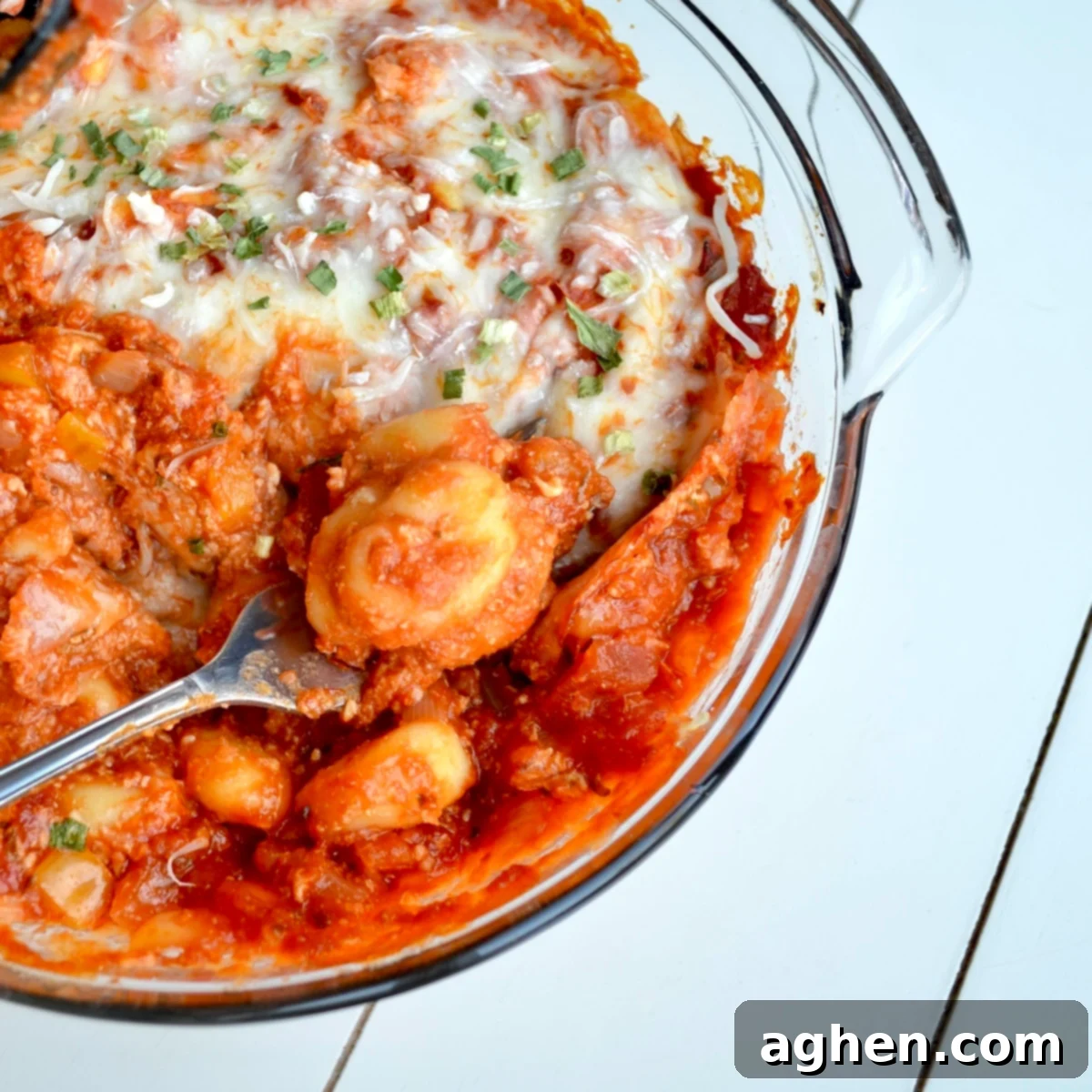A freshly baked Weight Watchers Cheesy Gnocchi Casserole, garnished with fresh parsley, in a baking dish, ready to be served.