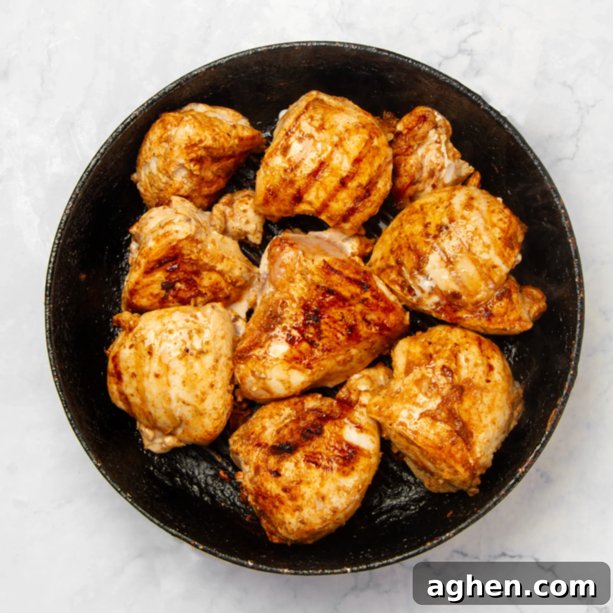 One-Pan Moroccan Chicken 5 Seasoned chicken breasts cooking in a pan.