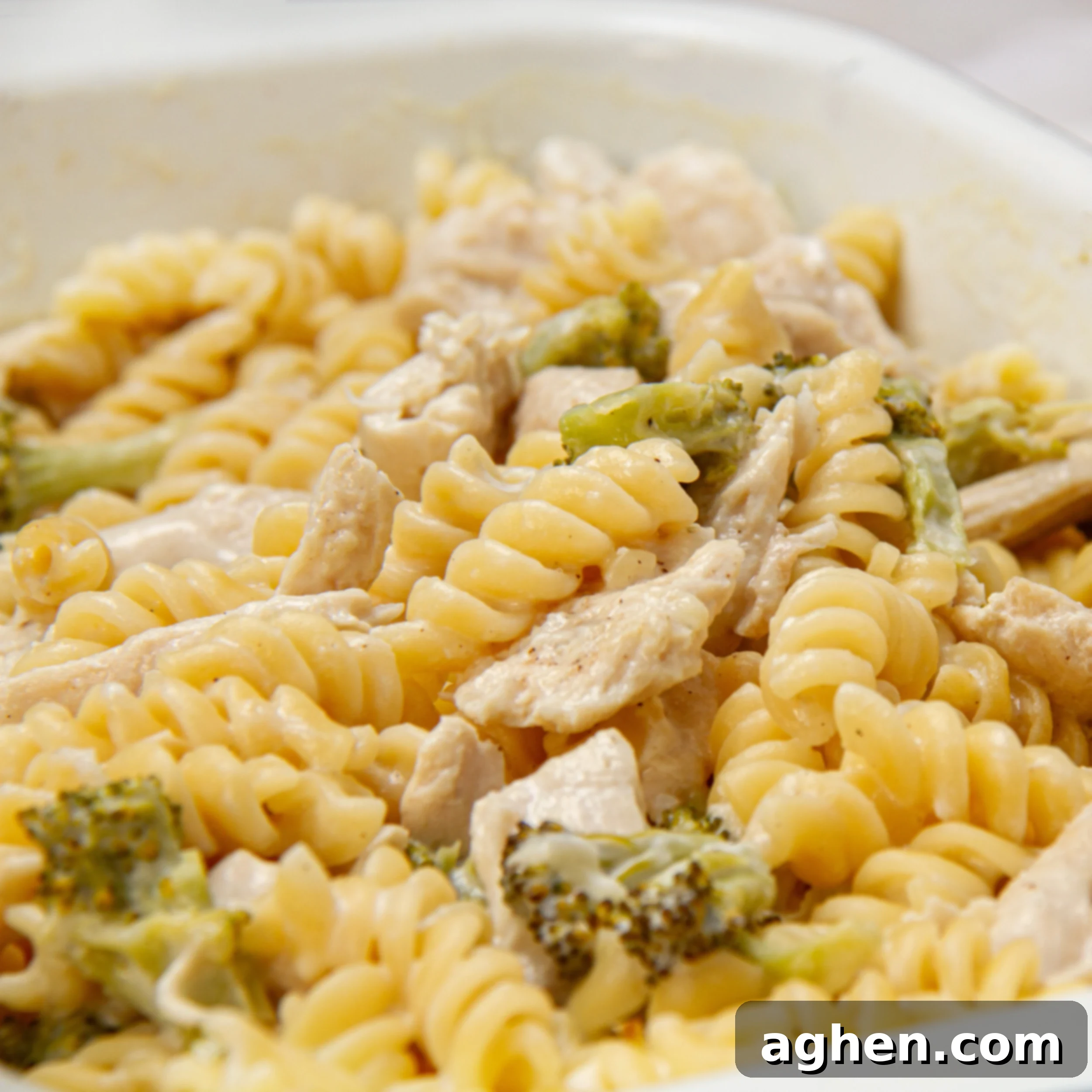 Creamy garlic parmesan chicken pasta in a baking dish, garnished with fresh parsley.