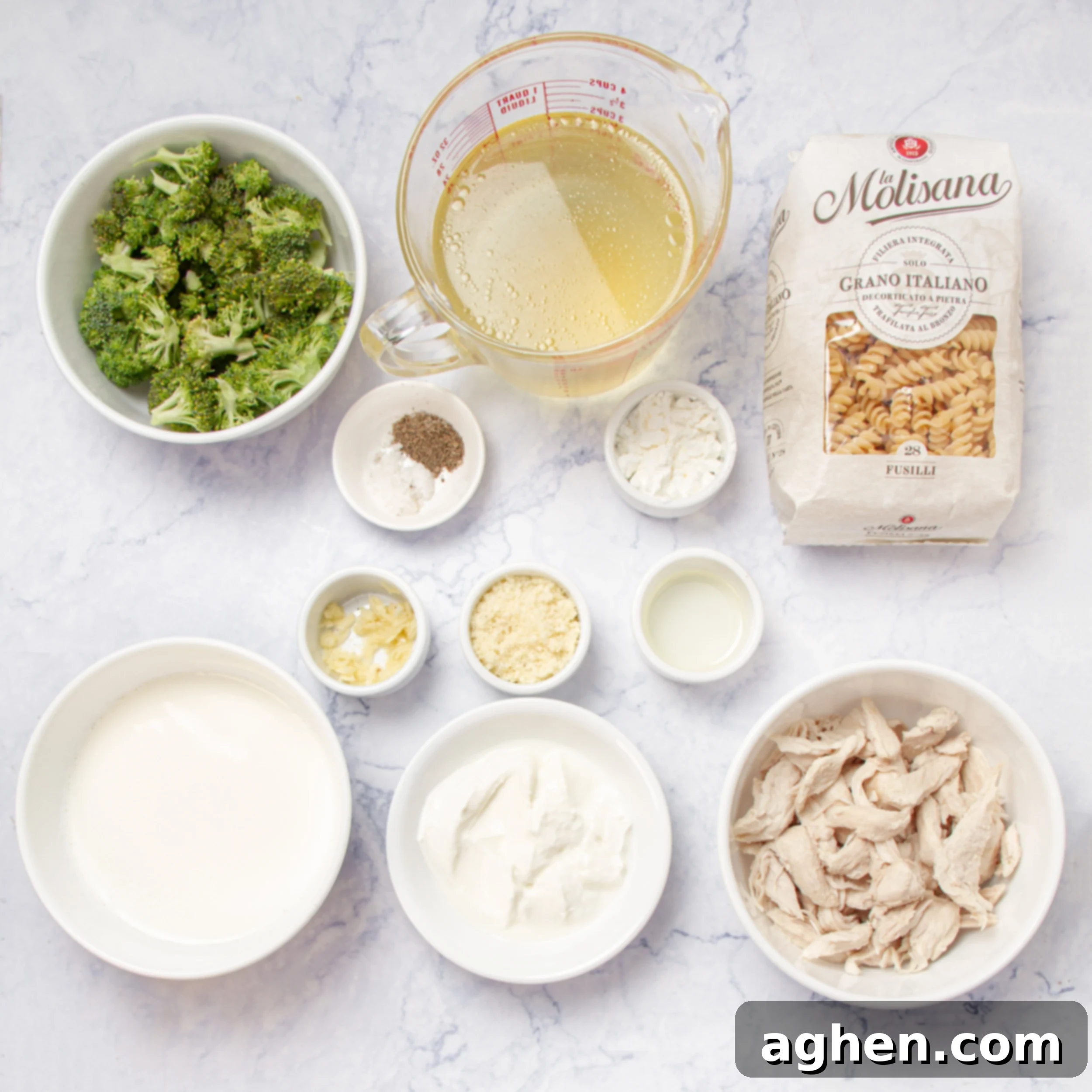 Individual bowls of ingredients including fusilli pasta, broccoli florets, skim milk, Greek yogurt, and Parmesan cheese.