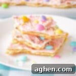 Pink white chocolate Easter bark with pastel M&Ms, Mini Eggs, and sprinkles.