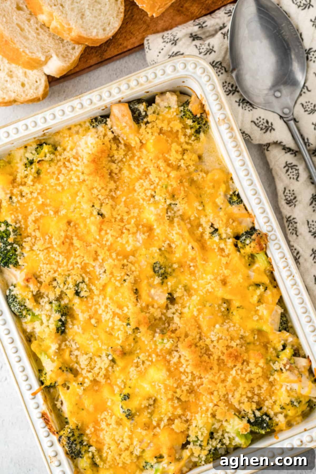 Chicken Divan Casserole in 9 x 13 inch baking dish with sliced bread next to it.