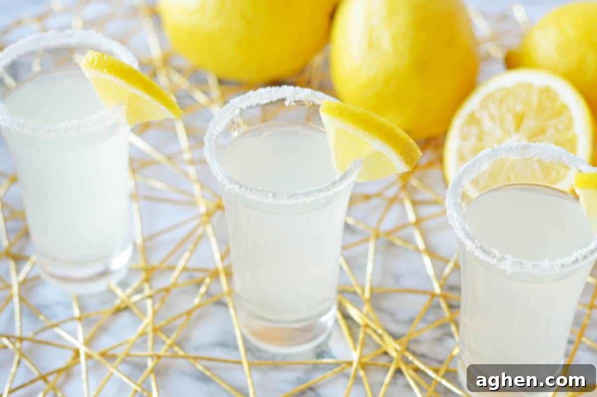 Three perfectly presented lemon drop shots, highlighting their vibrant color and enticing sugar rims, set for a party.