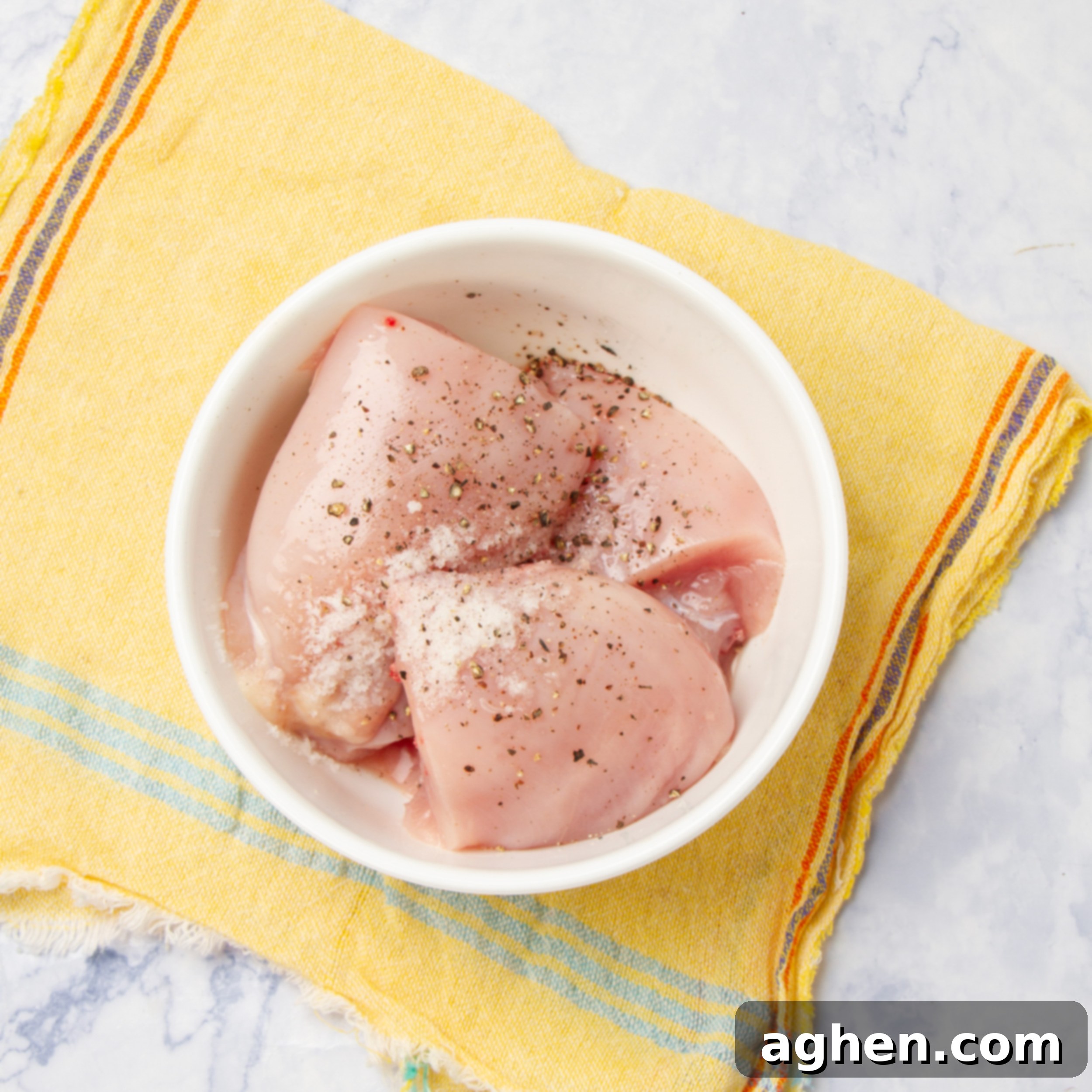 Chicken with spices in a small bowl. 