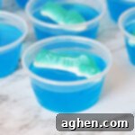 Shark jello shot with blue gelatin and shark gummy candy on top.