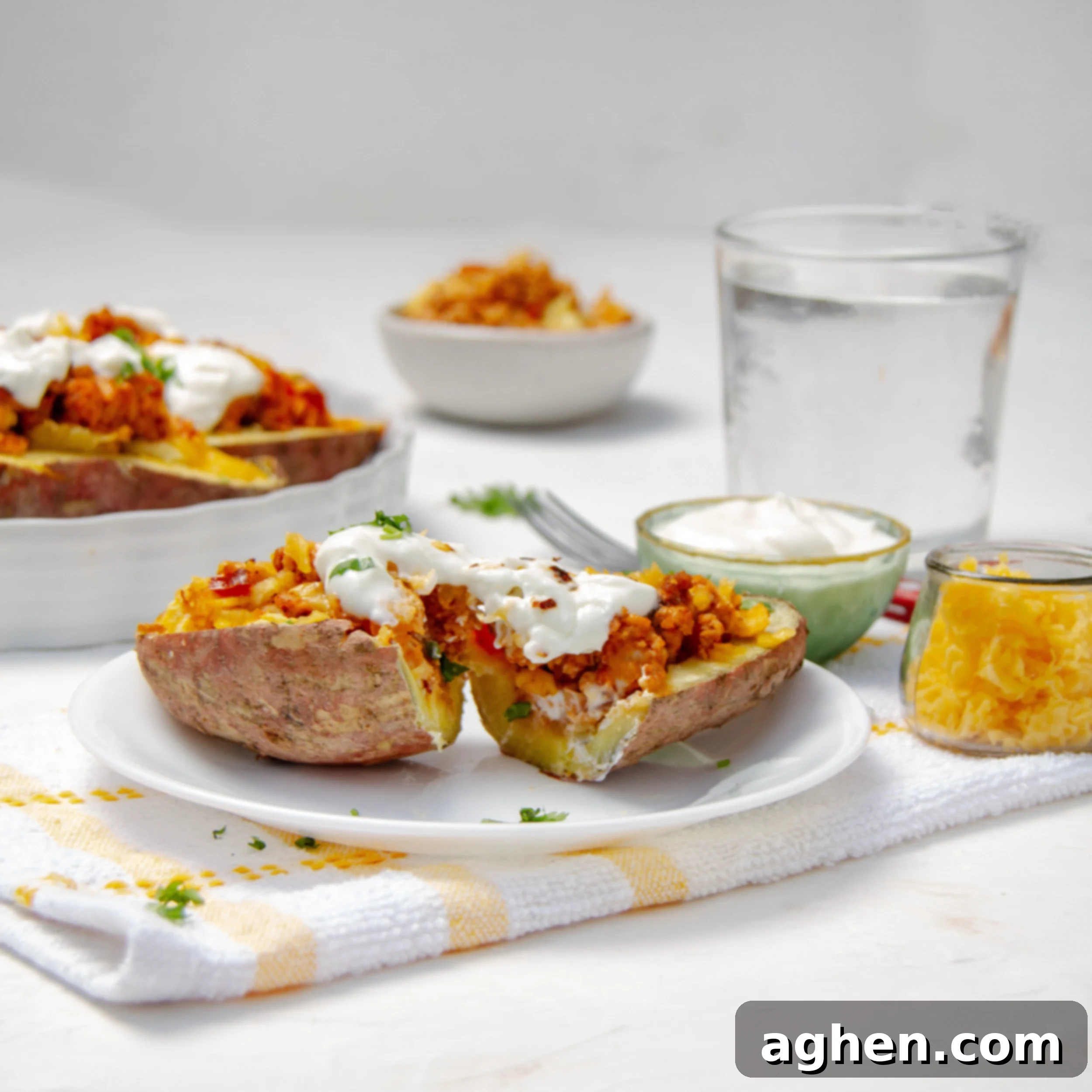 Creamy Baked Turkey-Stuffed Sweet Potatoes on a serving dish with sour cream on top. 