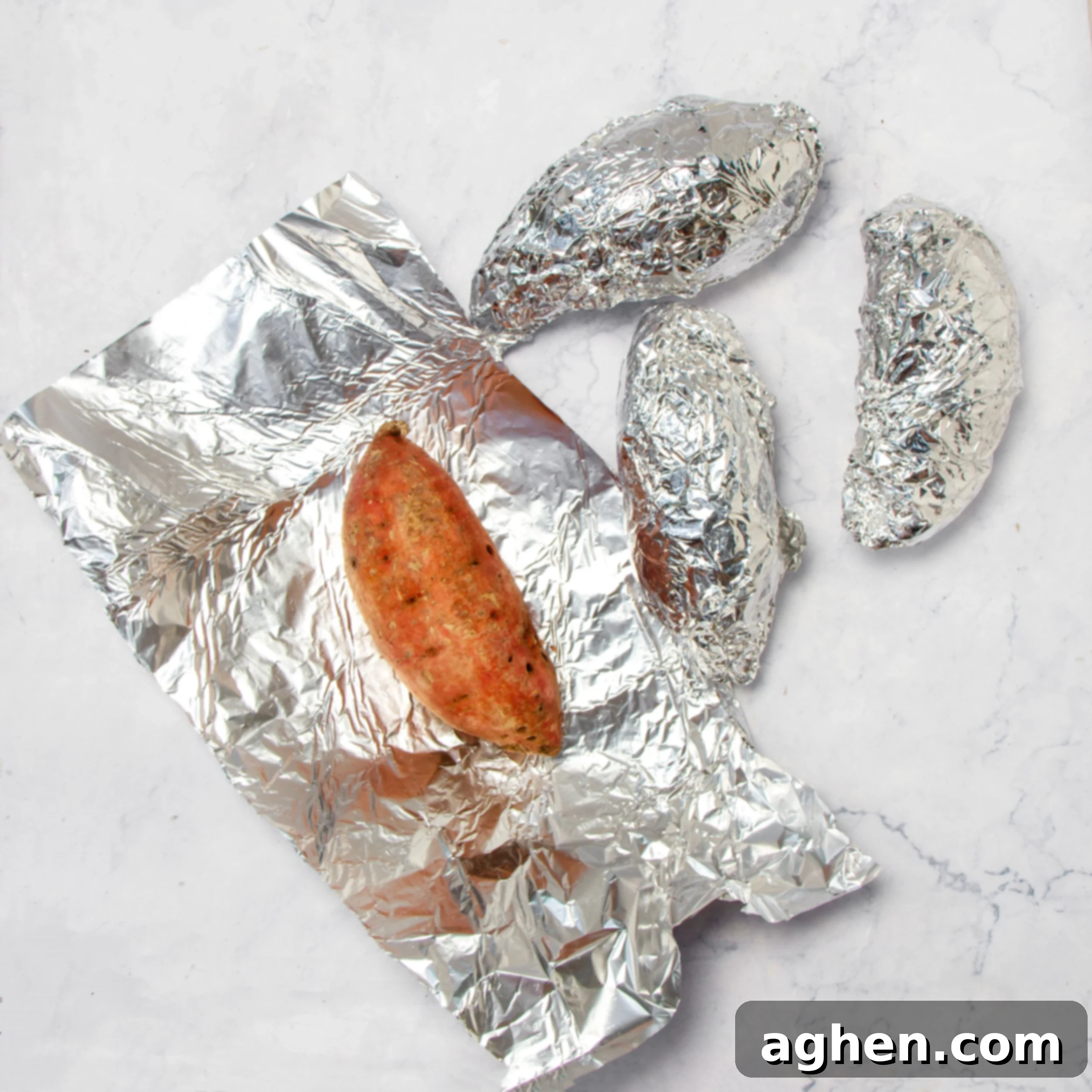 Sweet potatoes wrapped in tin foil ready for baking. 