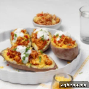 Creamy Baked Turkey-Stuffed Sweet Potatoes on a serving dish with sour cream on top.
