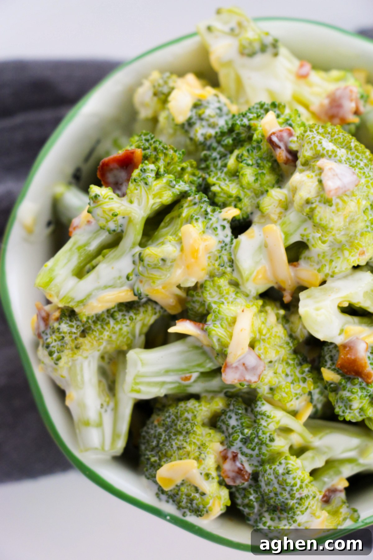Creamy Bacon Cheddar Broccoli Salad 3 Top-down photo of broccoli salad with crumbled bacon and shredded cheddar cheese.