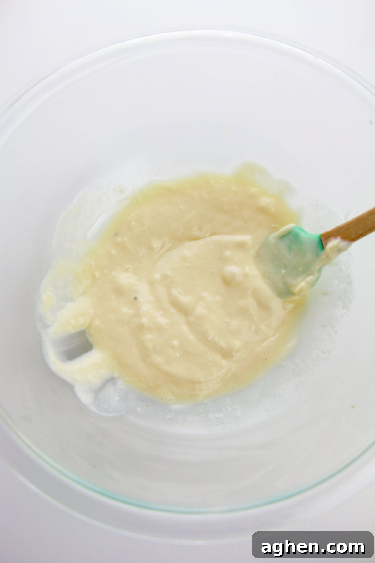 Creamy Bacon Cheddar Broccoli Salad 5 Creamy dressing in large glass bowl with a rubber spatula.
