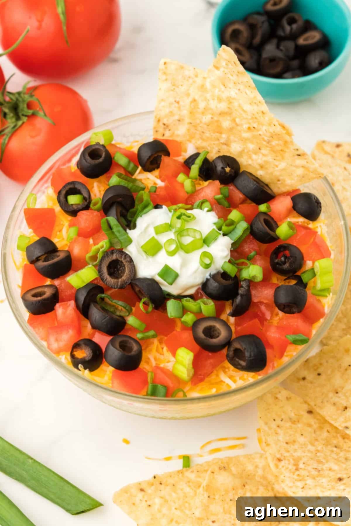 Seven Layer Taco Fiesta 12 Bowl of layered taco dip served with tortilla chips.