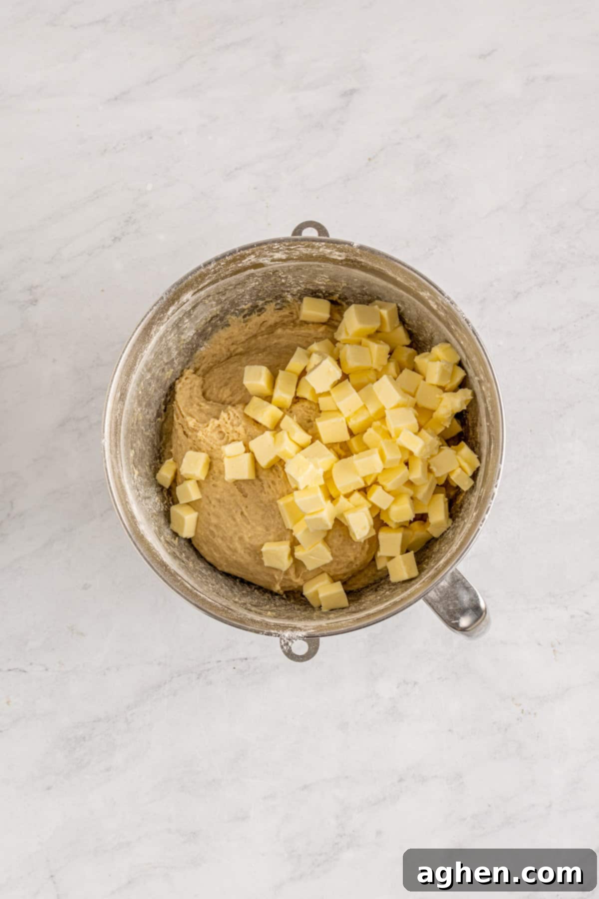 Cookies and Cream Dream Buns 6 Cubed softened butter being added to the mixing bowl with the developing dough, ready for further kneading.