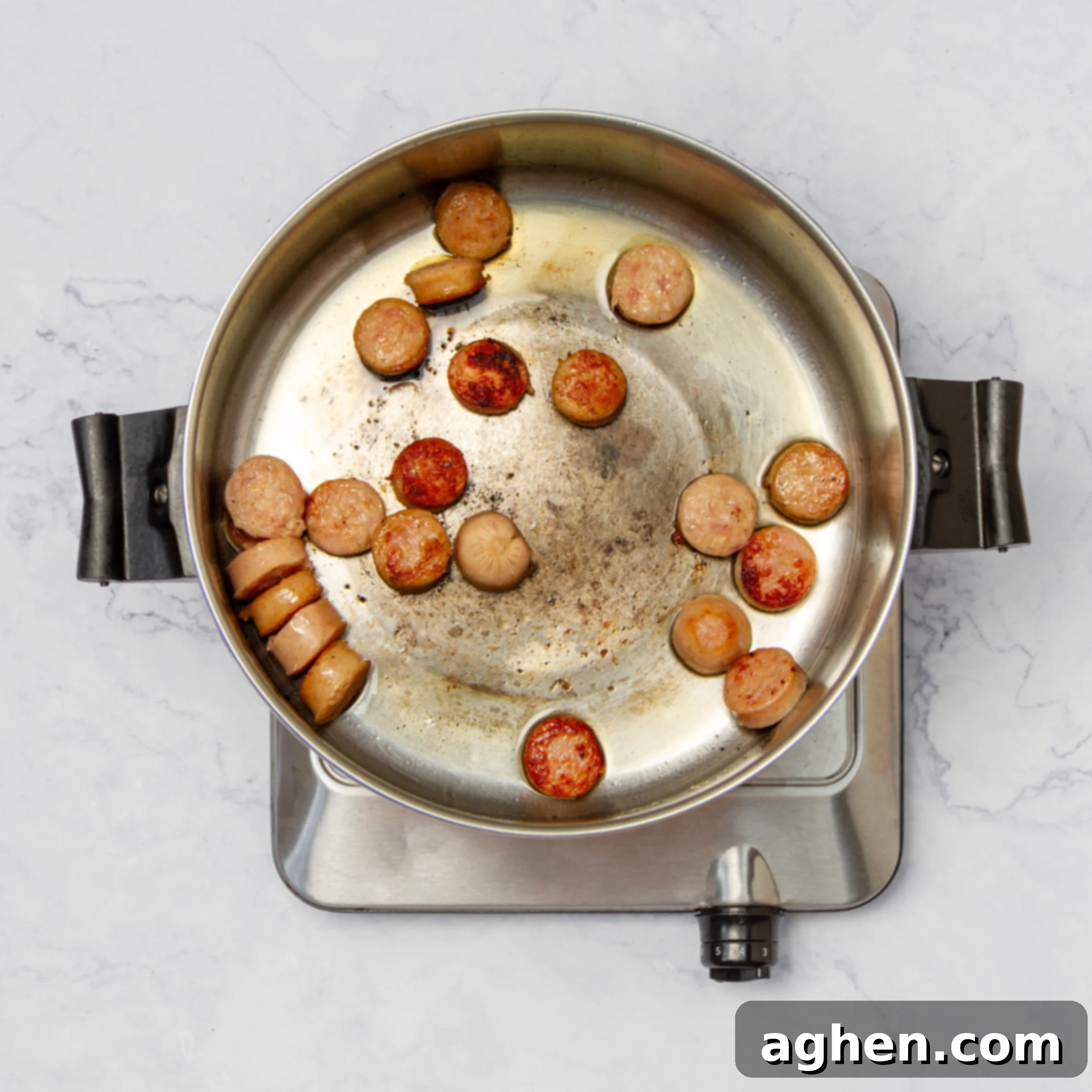 How to Make Weight Watchers Jambalaya 4 Sausage slices sautéing in a pan, lightly browned and releasing aroma.