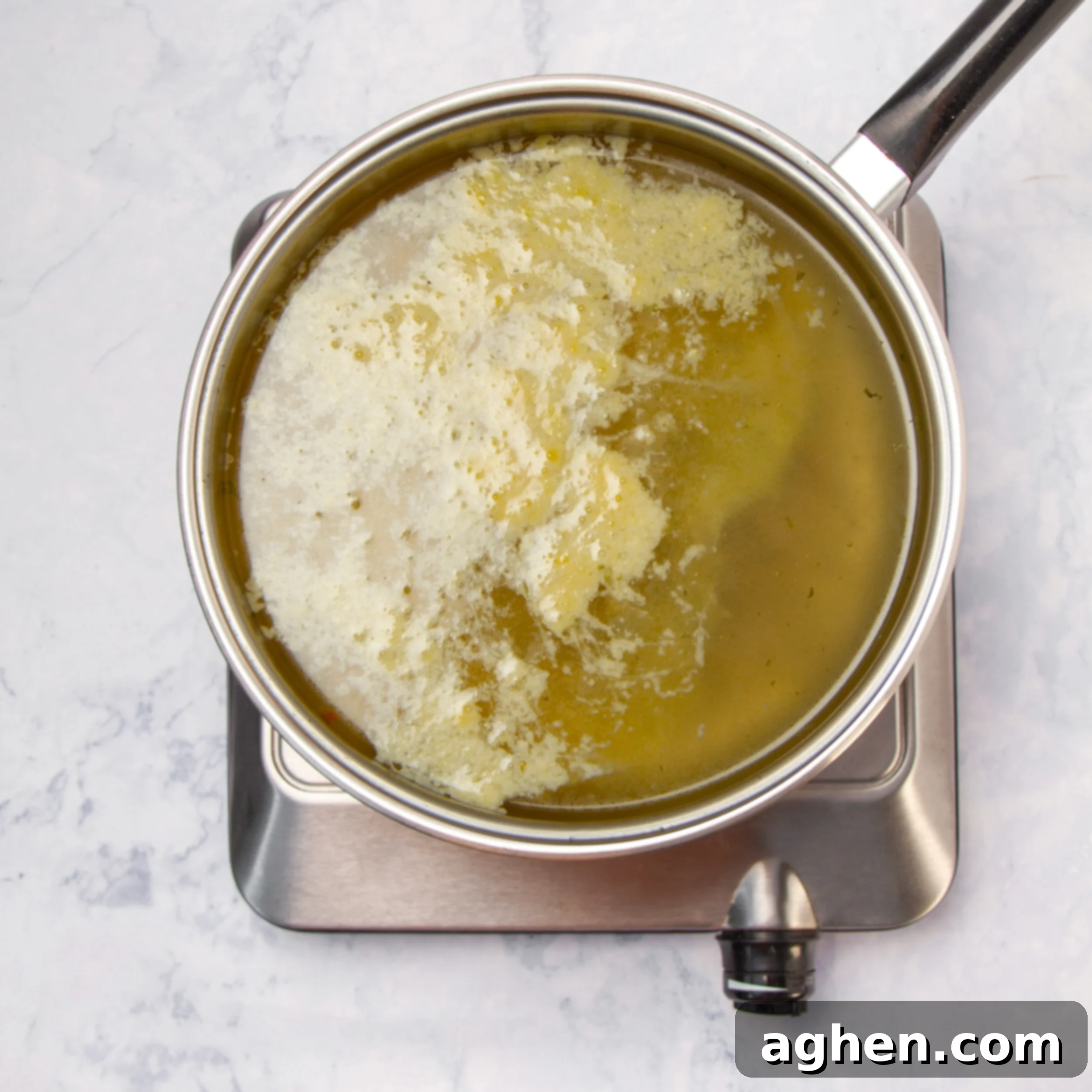 Classic Italian Stracciatella Soup 5 Egg mixture added to the soup broth in a soup pot.