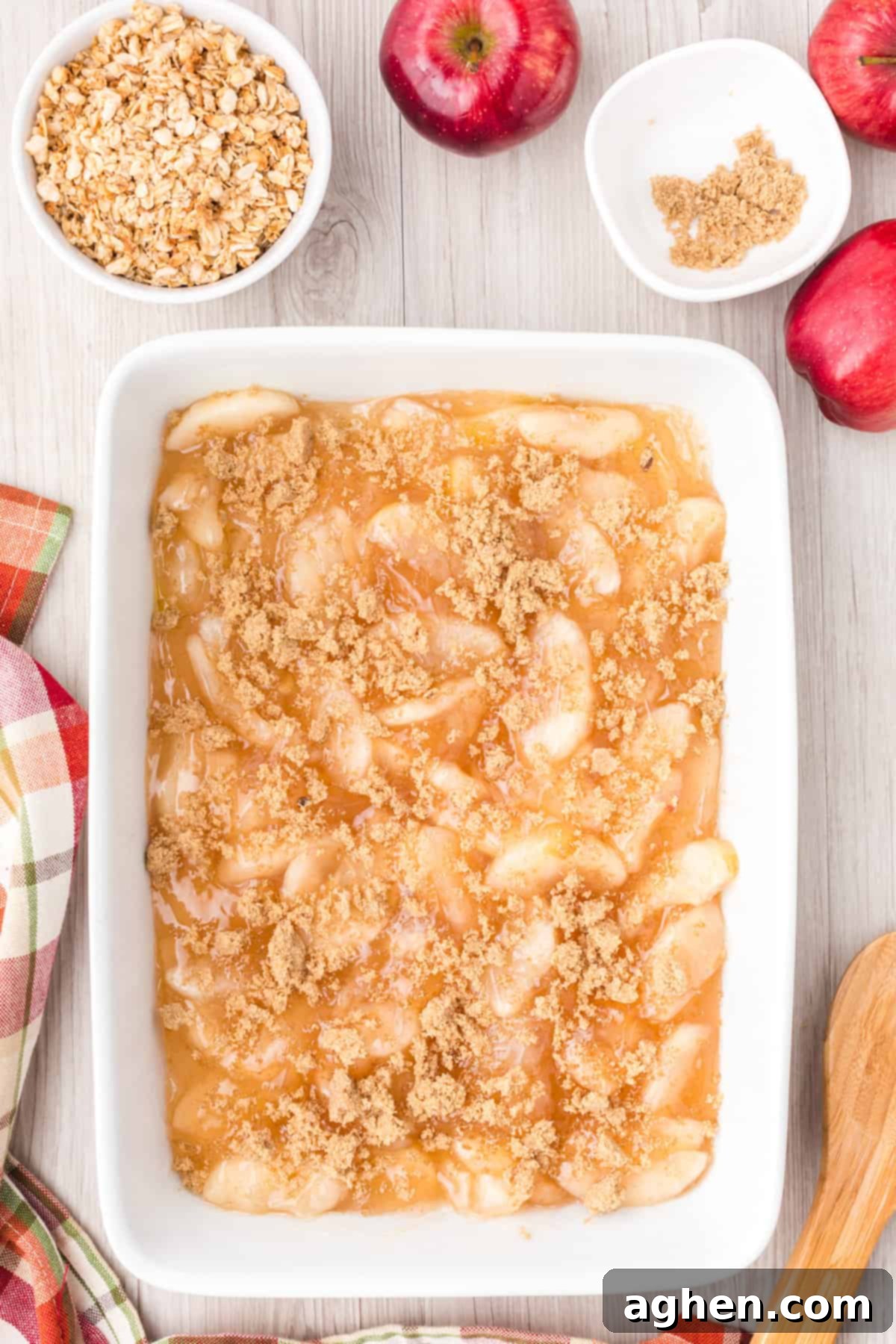Dark brown sugar sprinkled over the apple pie filling in pan.