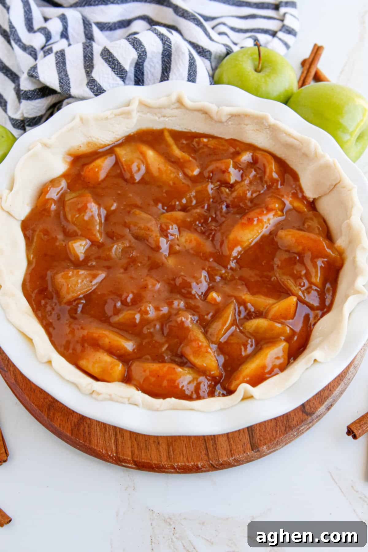 Homemade apple pie filling artfully arranged in a pie crust, ready for baking into a delicious pie.
