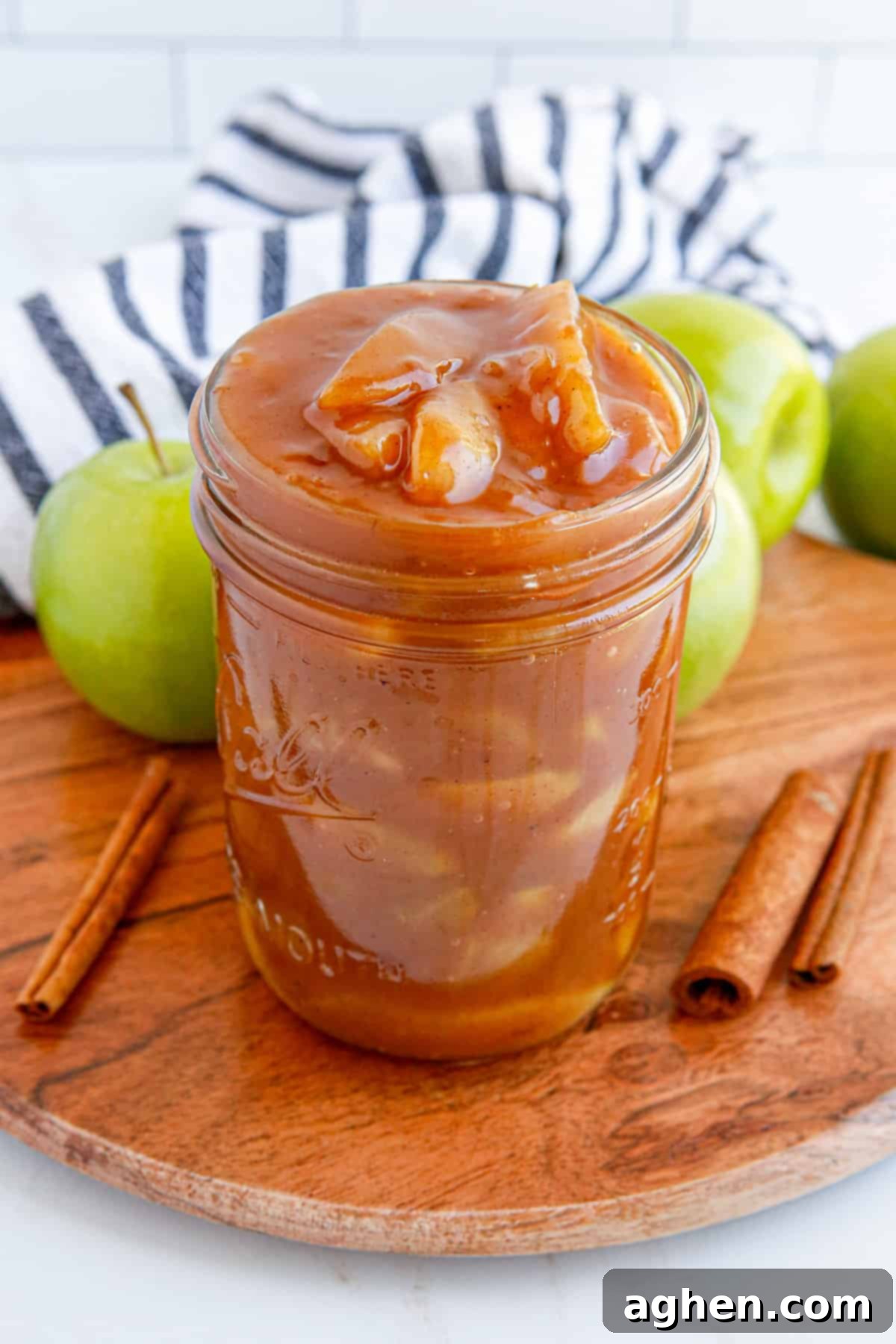 Homemade apple pie filling stored in a mason jar without a lid, ready to be sealed for preservation.