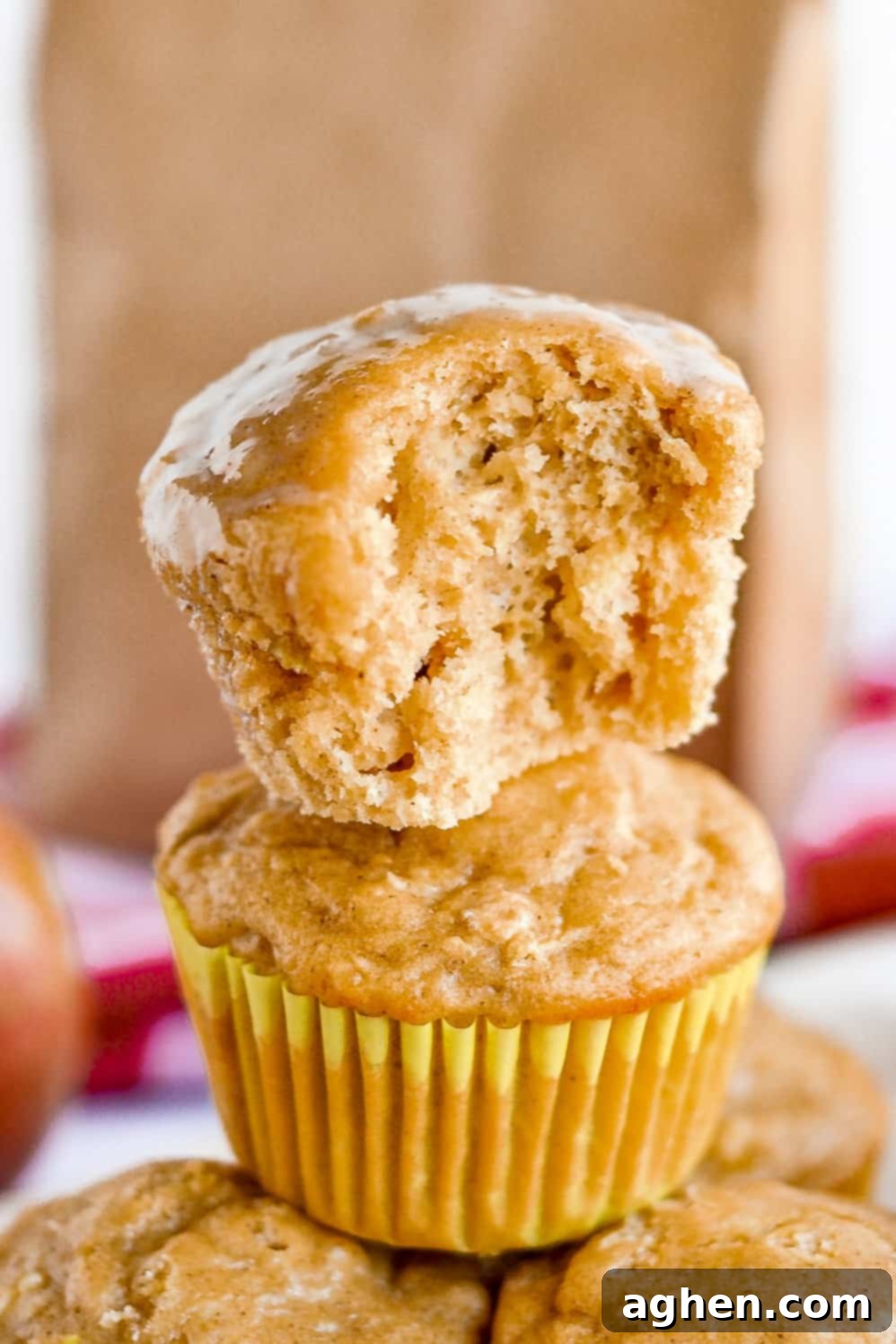 Apple muffin with bite taken out to show moist, tender crumb.