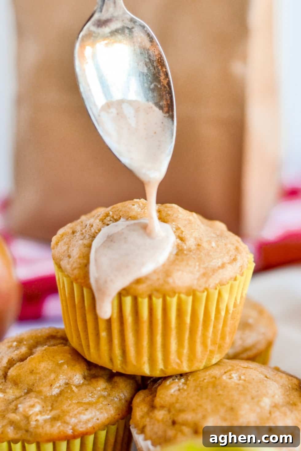 Apple Muffin with cinnamon glaze being poured over it.