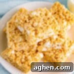 Bakery-style Rice Krispies Treats, sliced into perfect squares and stacked invitingly on a white plate, signifying a successful recipe.