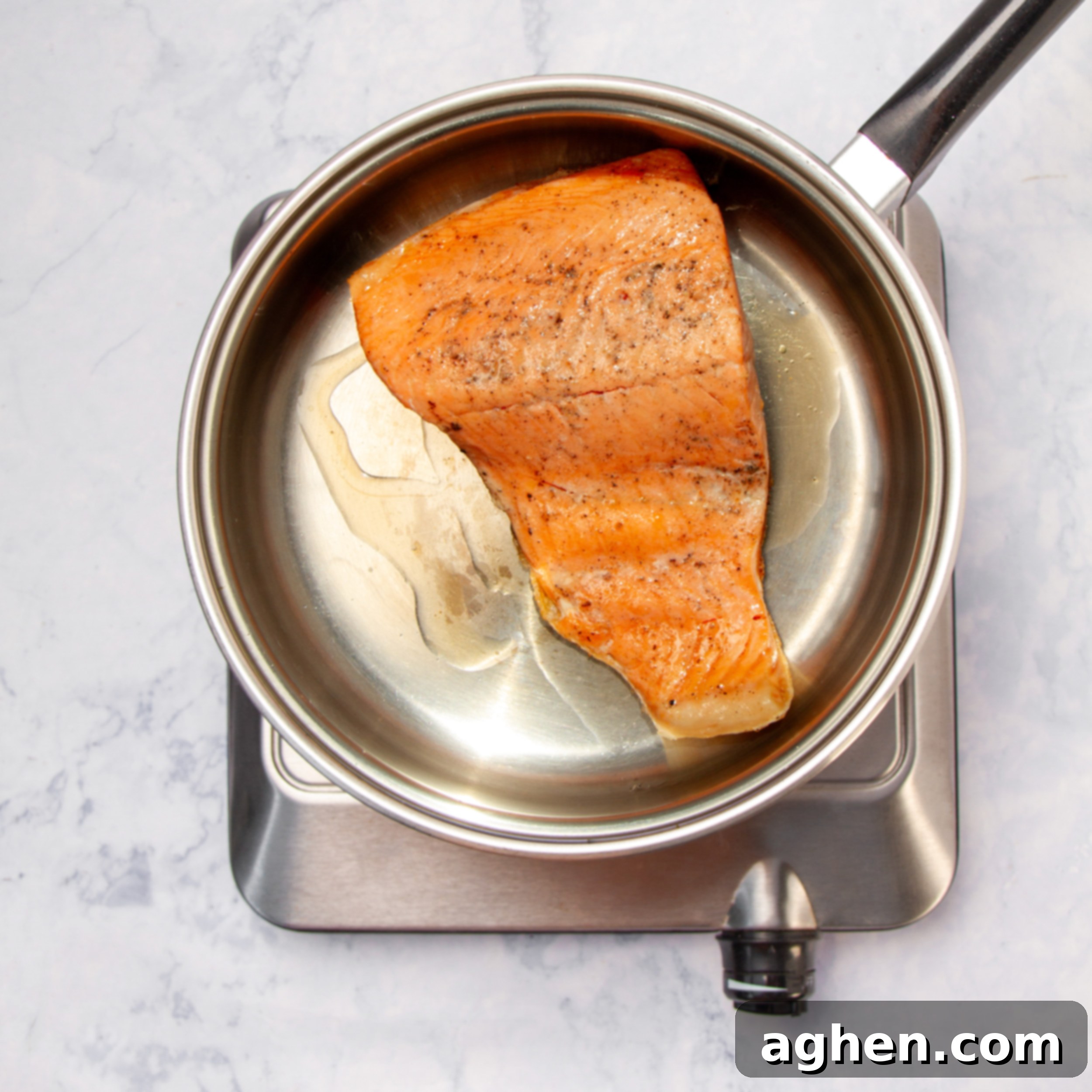Chimichurri Salmon: My Go-To Fish 6 Seasoned salmon filet cooking in a pan.