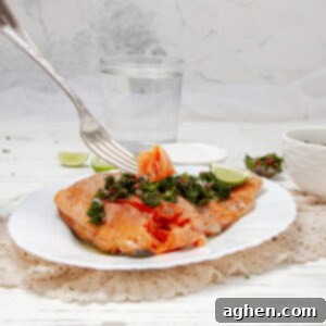 Chimichurri Salmon: My Go-To Fish 7 Flaky Chimichuri Salmon filet on a plate with fresh herb sauce on top.