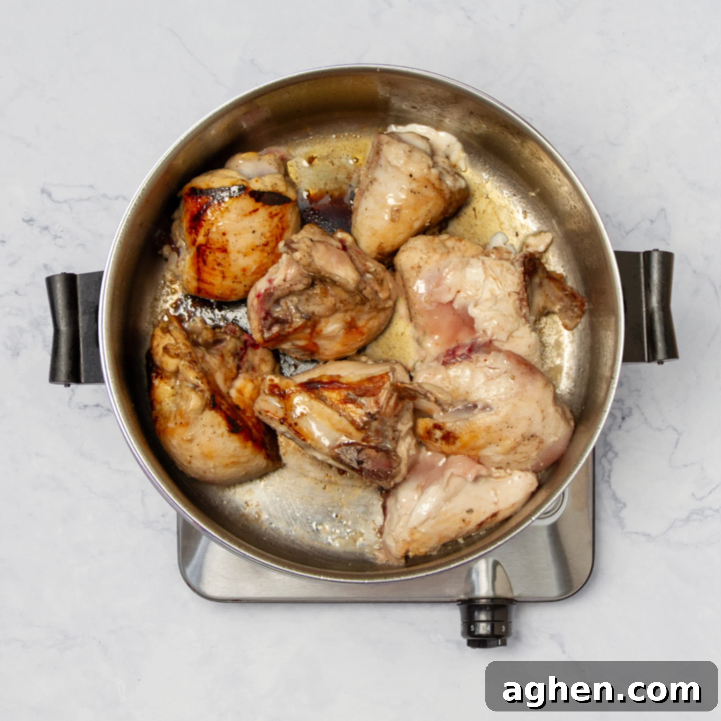 Chicken breasts cooking in a sauté pan. 