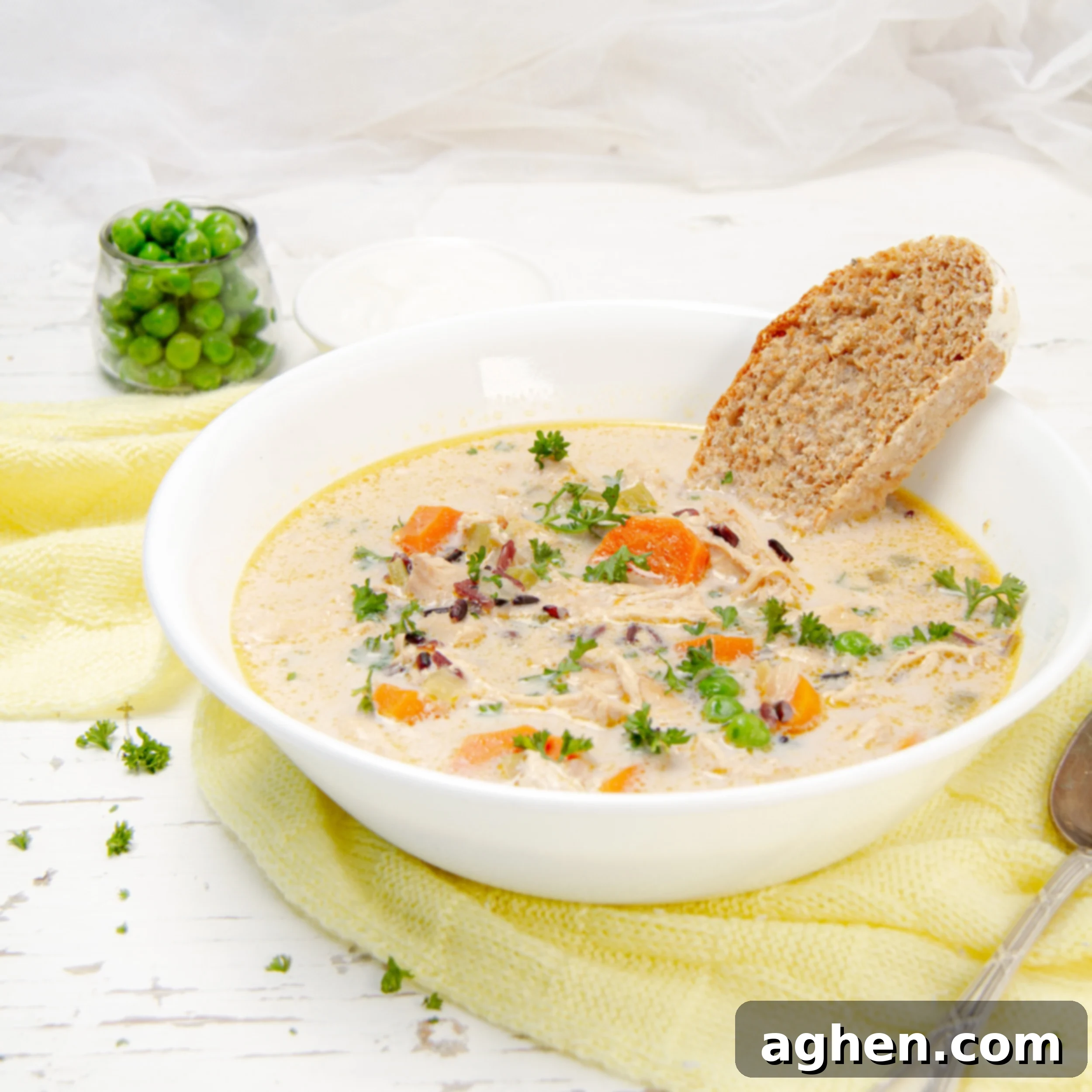 Creamy and nourishing Wild Rice Chicken Soup in a bowl with a piece of bread, showcasing its hearty texture and comforting appeal.