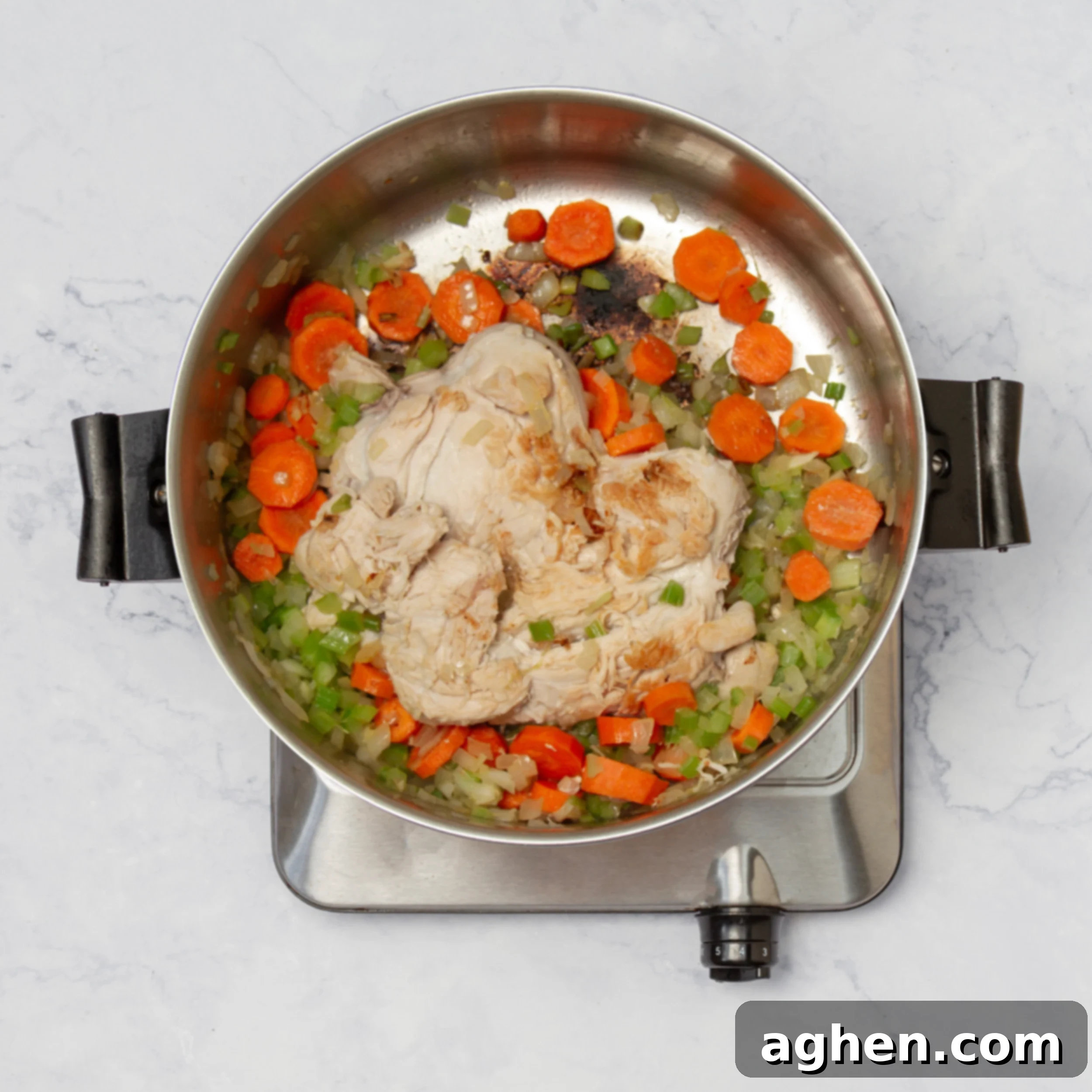 Chicken cooking in the pot over a bed of aromatic vegetables, sealing in its savory juices.