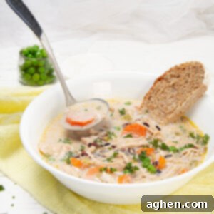 Creamy and nourishing Wild Rice Chicken Soup in a bowl with a piece of bread, showcasing its hearty texture and comforting appeal.