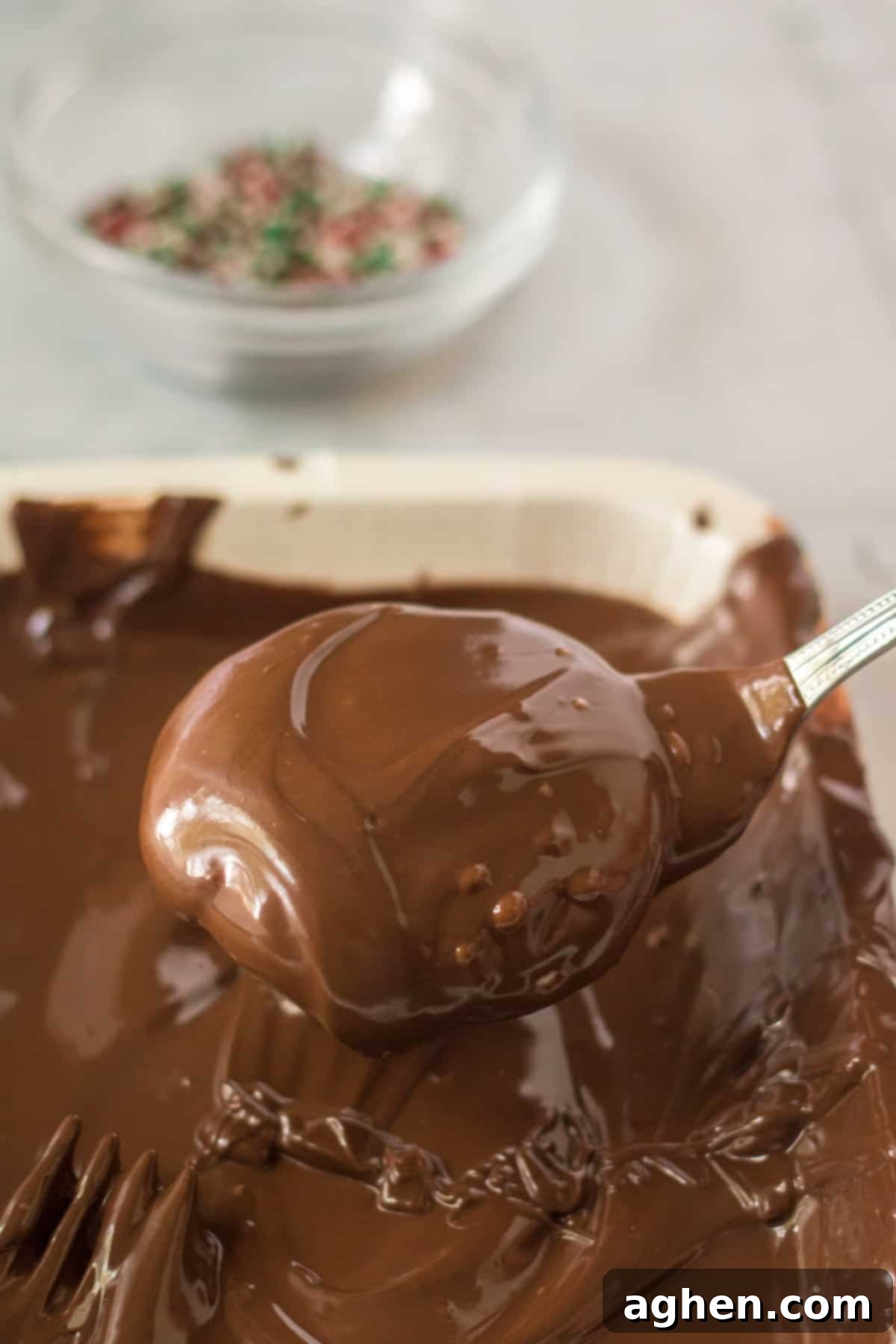 Easy Homemade Peppermint Patties 9 Homemade peppermint patties being dipped in melted chocolate.