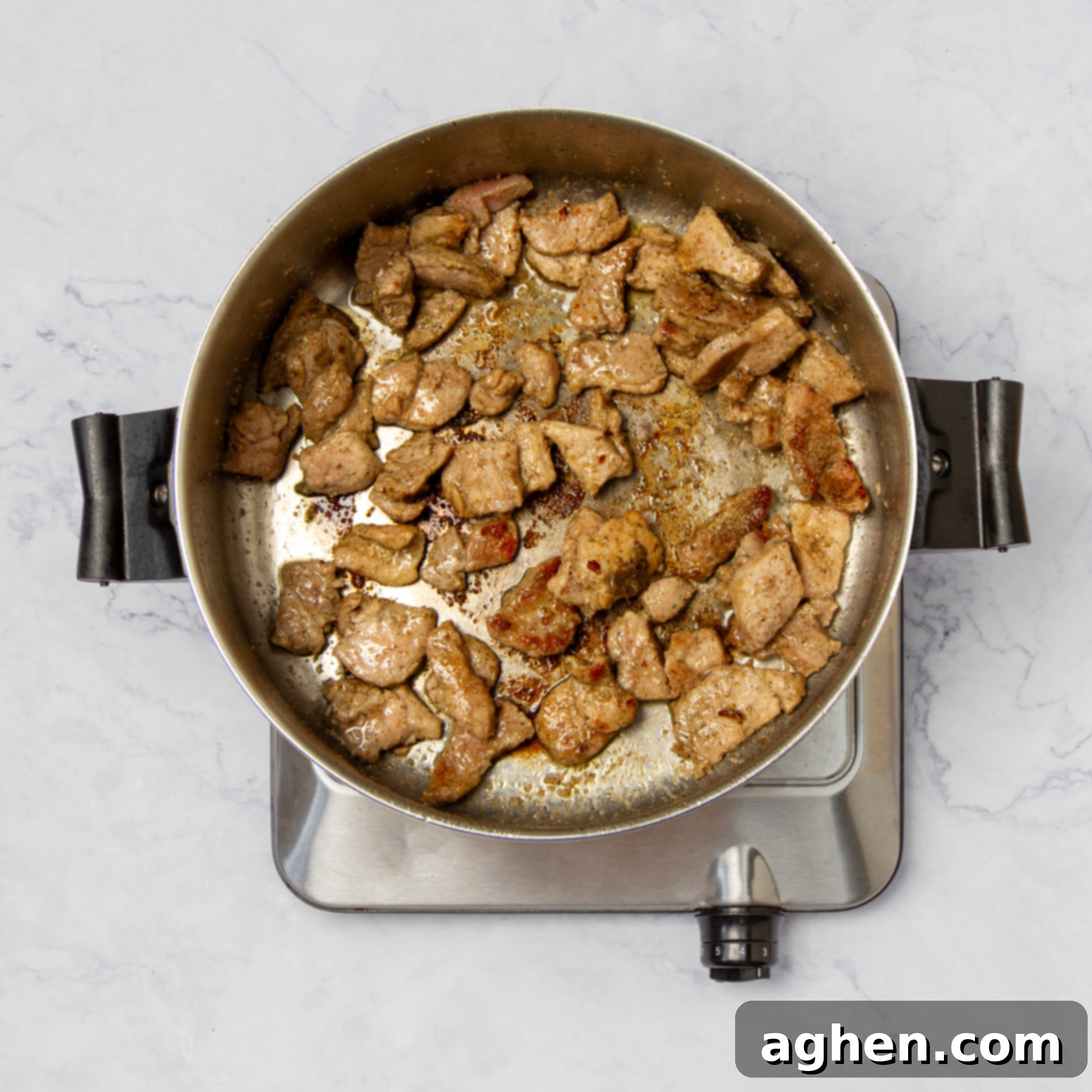 Pork sautéing in a soup pot. 