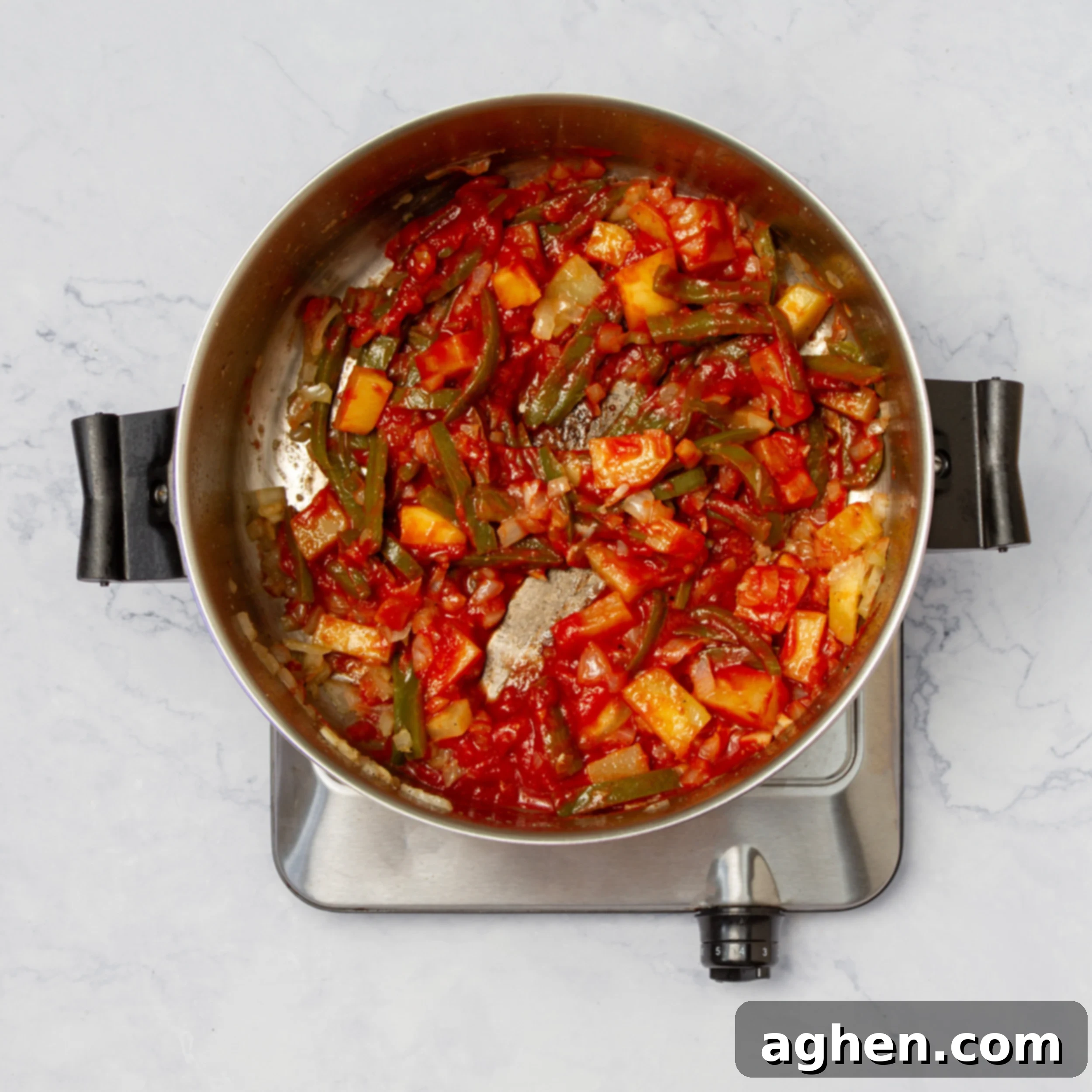 Aromatics, vegetables, and tomato paste sautéing in a soup pot. 