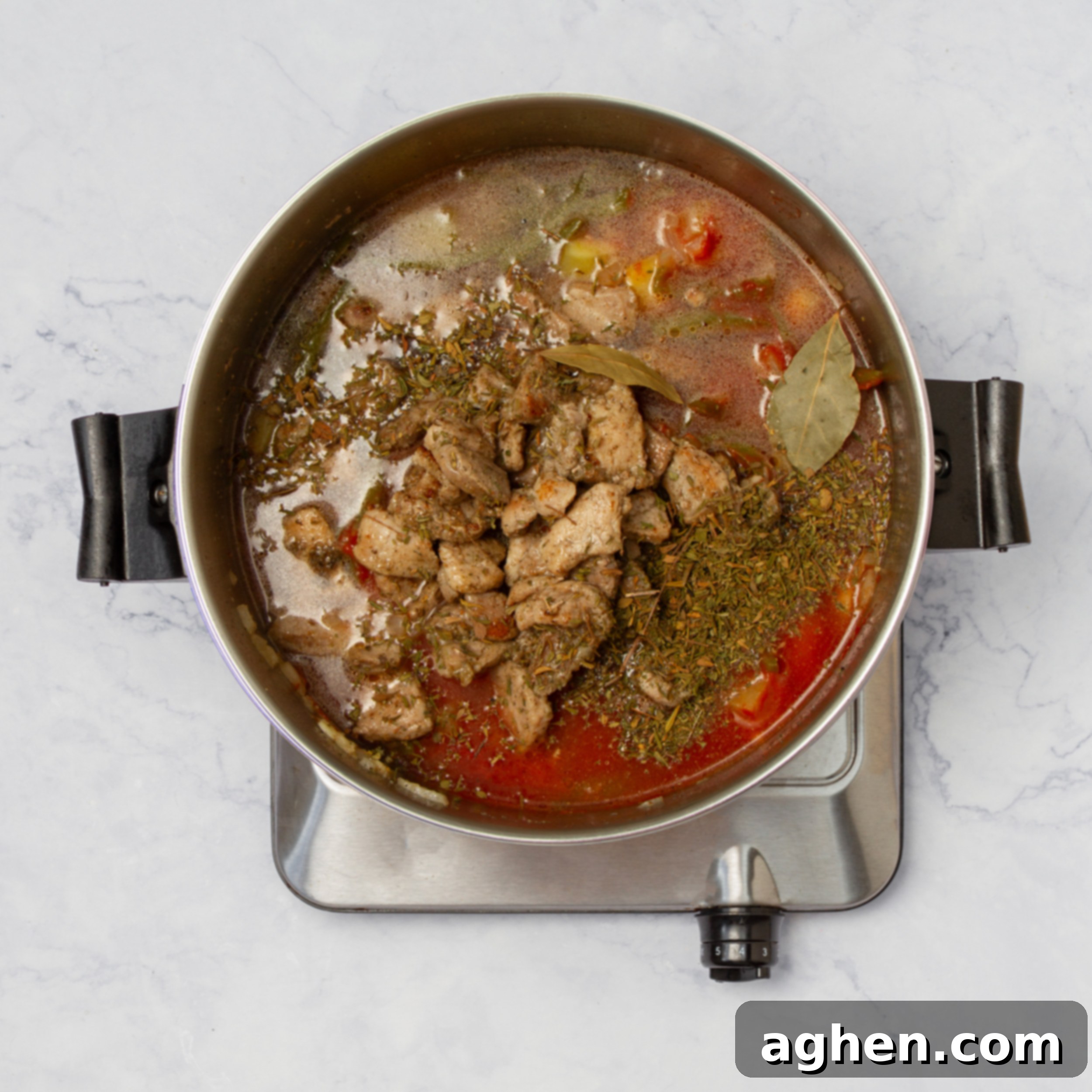 All soup ingredients simmering in broth in a soup pot. 