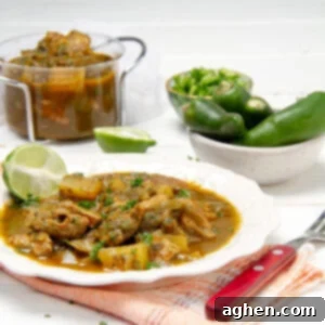 Thick and meaty Green Chili Stew in a bowl with whole peppers on the side.