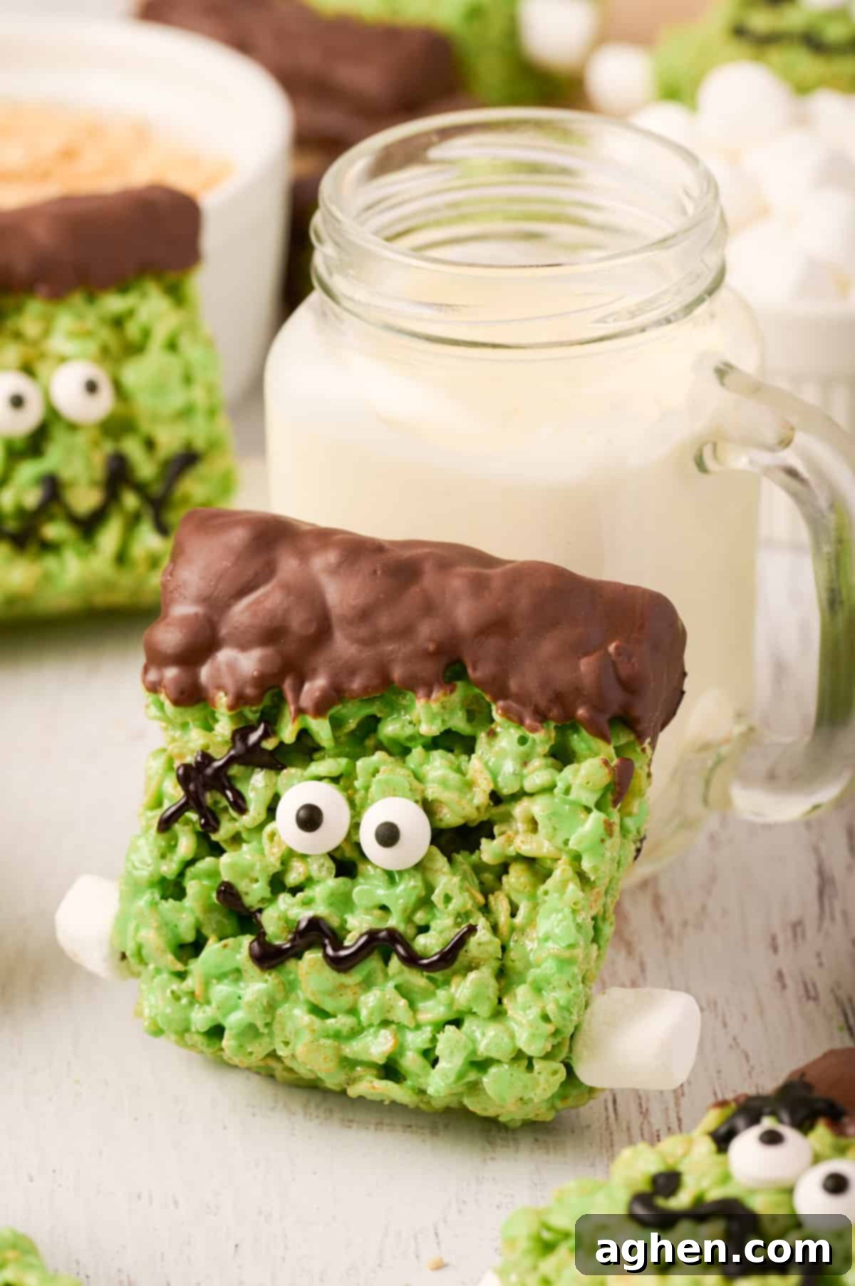 Frankenstein rice krispie treat leaning against glass of milk.