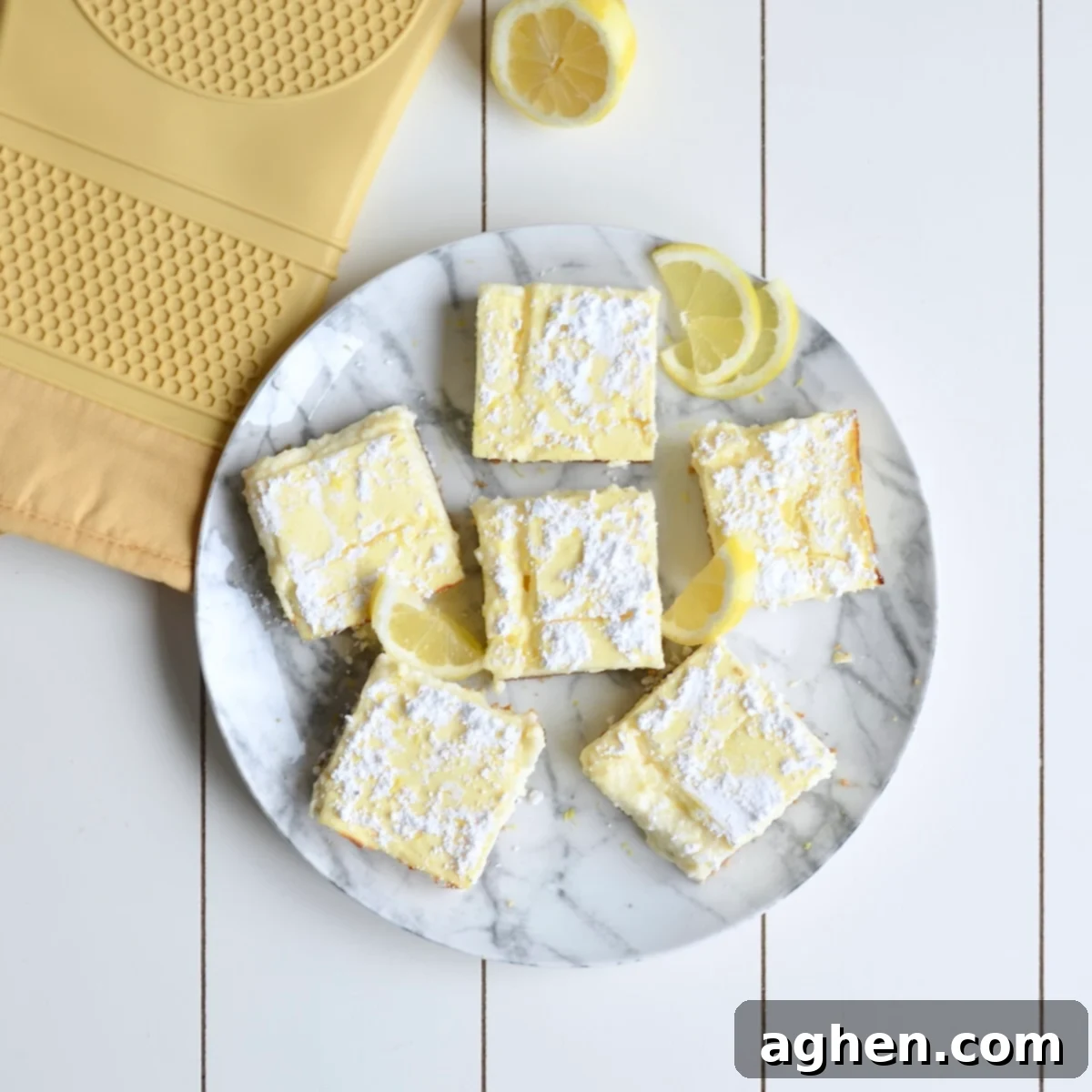 A serving of freshly baked and sliced lemon cheesecake bars on a decorative plate.