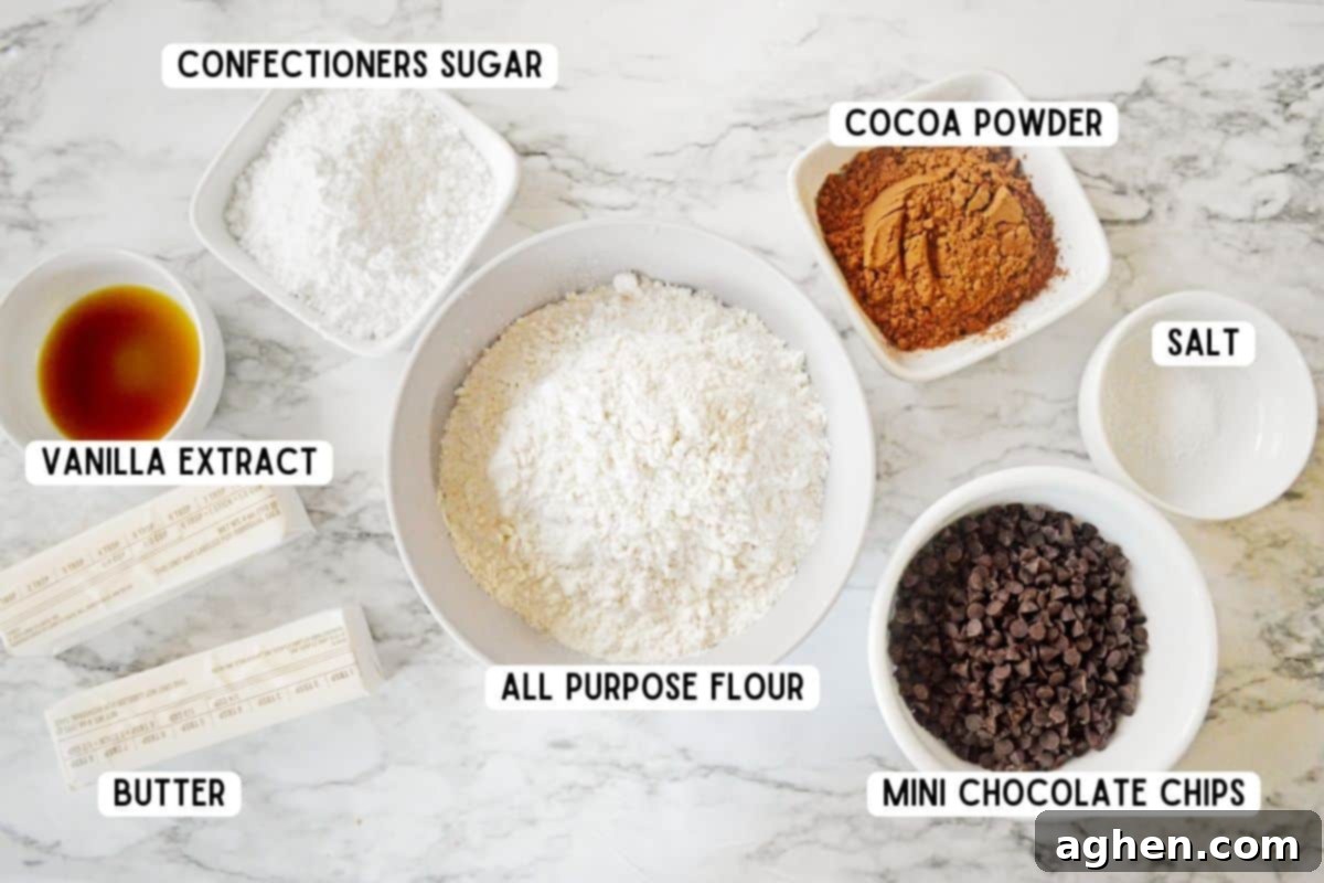 Decadent Double Chocolate Snowballs 4 A selection of ingredients neatly laid out on a surface, ready for making Double Chocolate Snowball Cookies, including butter, flour, cocoa powder, chocolate chips, and powdered sugar.