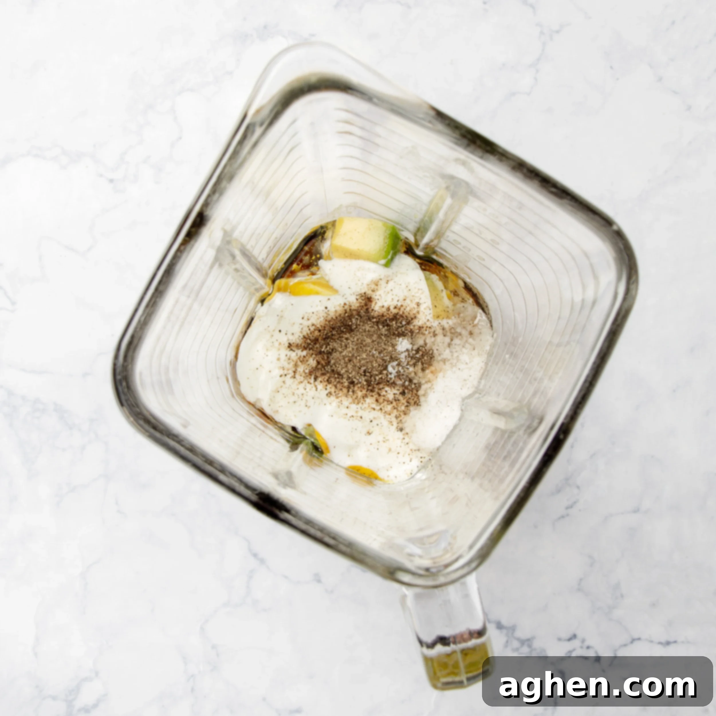 Ingredients for the creamy Greek yogurt dressing being blended in a food processor, showing the smooth texture.