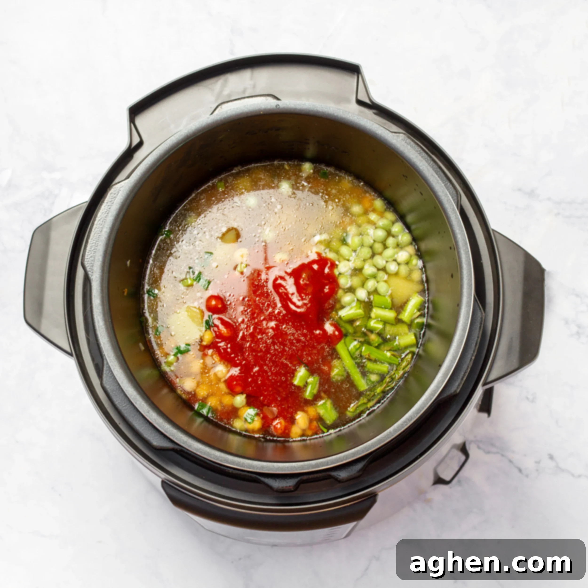 Minestrone's Spring Awakening: A Fresh Spin on the Classic 4 All veggies, tomato paste, and broth added to the sautéed aromatics in the pressure cooker, illustrating the layering of ingredients.