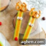 Festive Peanut Butter Antler Crunch 11 Celery reindeer decorated with pretzels, candy eyes, and M&Ms.